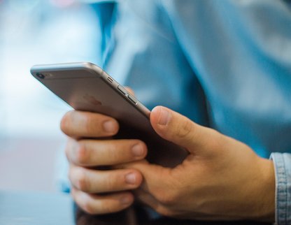 Billede af mand der holder en mobiltelefon