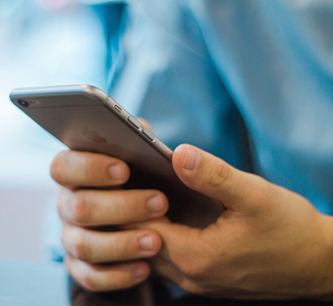Billede af mand der holder en mobiltelefon