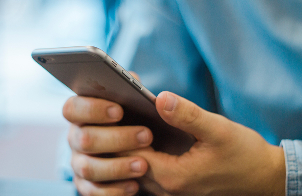 Billede af mand der holder en mobiltelefon